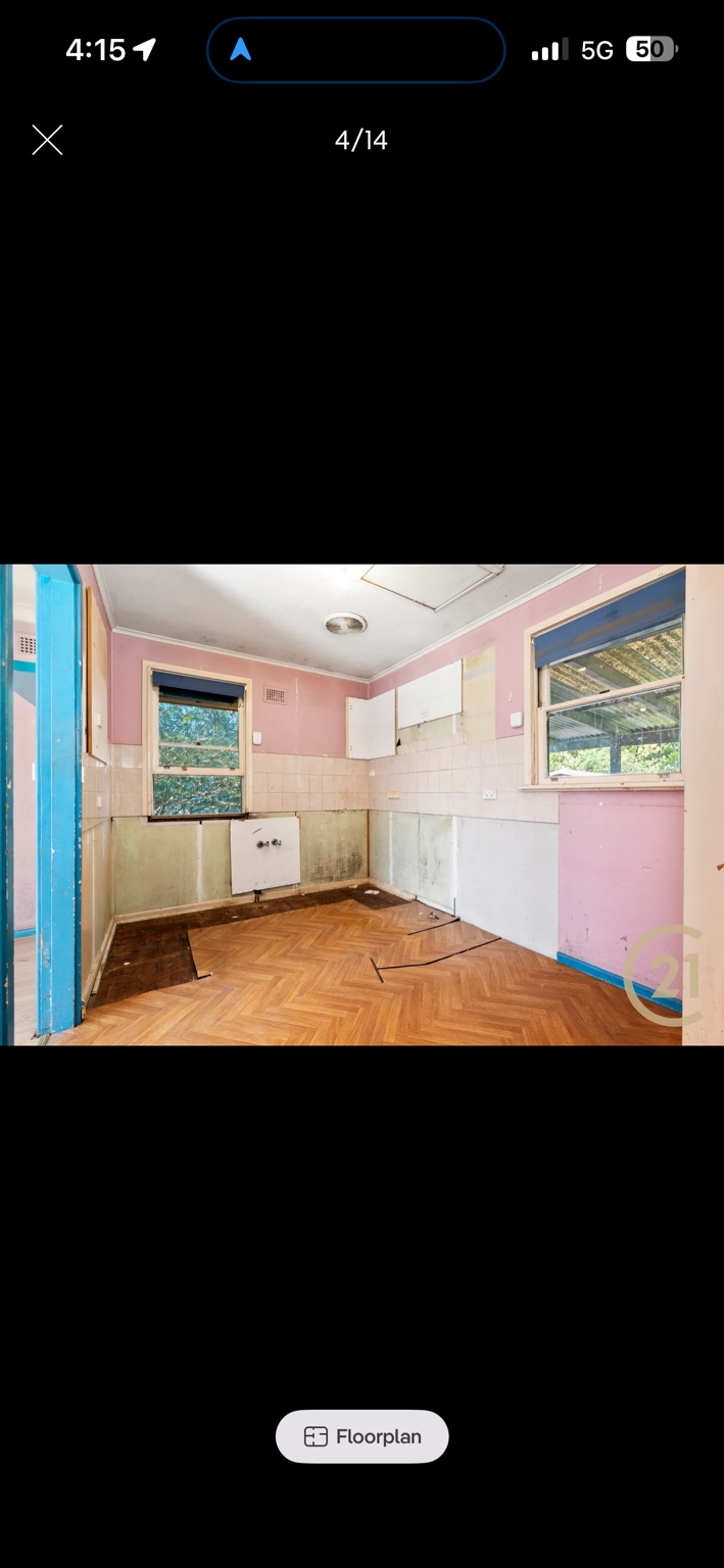Ashcroft kitchen before renovation, with dated pink walls and removed cabinetry